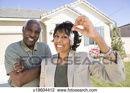 Portrait of middle-aged couple with keys to new house View Large Photo Image Stock Image - Portrait of middle-aged couple with keys to new house. Fotosearch