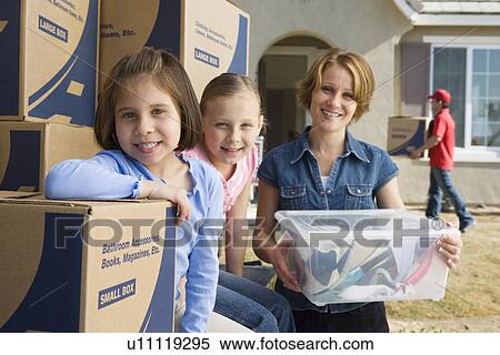 Portrait of mother with two daughters (6-9) by cardboard boxes View Large Photo Image Stock Photography - Portrait of mother with two daughters (6-9) by cardboard boxes. Fotosearch