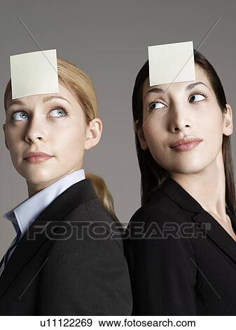 Portrait of two female office workers with sticky notes on forehead View Large Photo Image Stock Photo - Portrait of two female office workers with sticky notes on forehead. Fotosearch