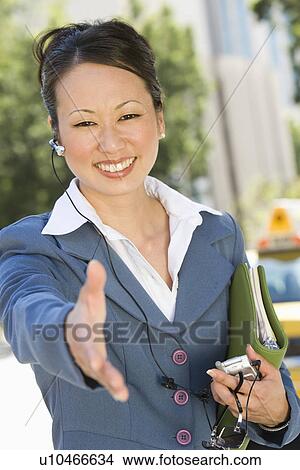Portrait of young businesswoman with extended hand, smiling View Large Photo Image Picture - Portrait of young businesswoman with extended hand, smiling. Fotosearch