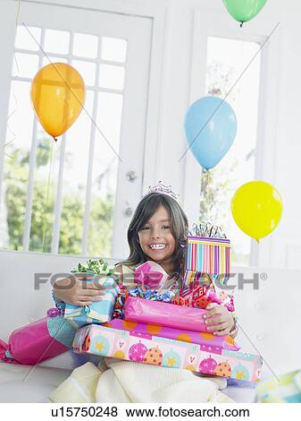 Portrait of young girl (7-9) with birthday presents, smiling View Large Photo Image Stock Photo - Portrait of young girl (7-9) with birthday presents, smiling. Fotosearch
