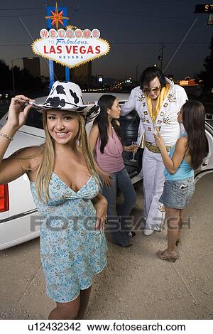 Portrait of young woman, two women with Elvis impersonator in background, Las Vegas, Nevada, USA View Large Photo Image Stock Image - Portrait of young woman, two women with Elvis impersonator in background, Las Vegas, Nevada, USA. Fotosearch