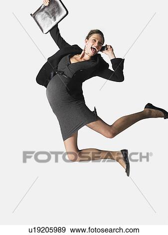 Pregnant Businesswoman on cell phone jumping, mid air View Large Photo Image Stock Photo - Pregnant Businesswoman on cell phone jumping, mid air. Fotosearch