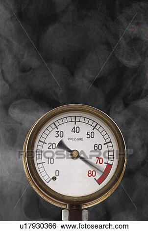 Stock Photograph - Pressure gauge at maximum omitting smoke in studio. Fotosearch