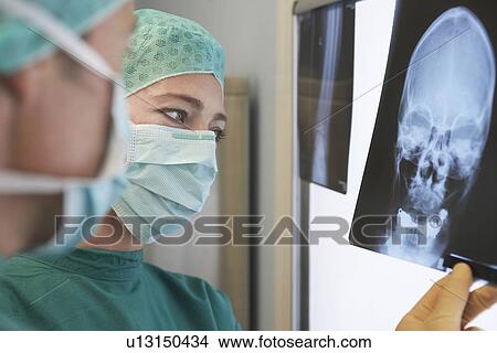 Radiologists Examining X-Ray of skull, close up View Large Photo Image Picture - Radiologists Examining X-Ray of skull, close up. Fotosearch