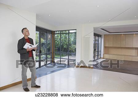 Real estate agent observing new property View Large Photo Image Stock Photo - Real estate agent observing new property. Fotosearch