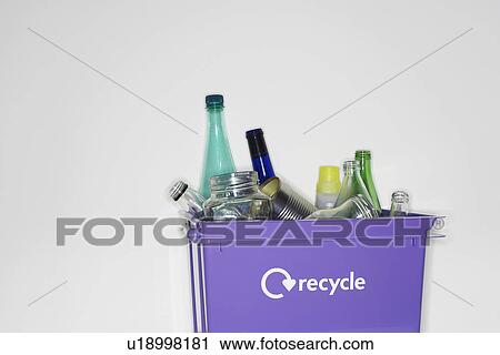 Stock Image - Recycling container filled with empty jars and bottles. Fotosearch