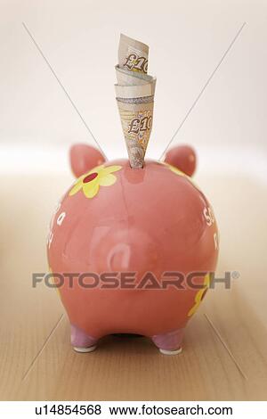 Rolled banknotes sticking out of piggy bank, back view View Large Photo Image Stock Photo - Rolled banknotes sticking out of piggy bank, back view. Fotosearch