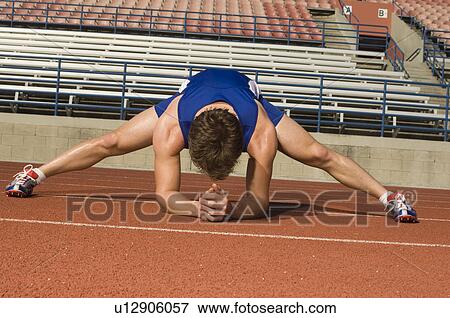 Runner on a track, stretching View Large Photo Image Stock Photo - Runner on a track, stretching. Fotosearch
