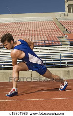 Runner on a track, stretching View Large Photo Image Stock Photograph - Runner on a track, stretching. Fotosearch