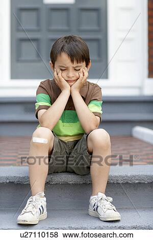 Sad little boy sitting on front steps of house View Large Photo Image Stock Photo - Sad little boy sitting on front steps of house. Fotosearch