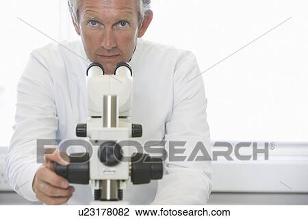 Scientist working behind microscope in laboratory View Large Photo Image Stock Image - Scientist working behind microscope in laboratory. Fotosearch