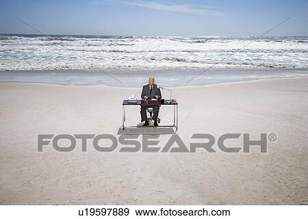 Senior business man sitting at office desk on beach, elevated view View Large Photo Image Stock Photo - Senior business man sitting at office desk on beach, elevated view. Fotosearch