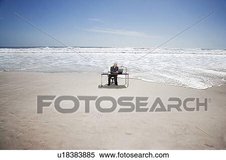 Senior business man sitting at office desk on beach, elevated view View Large Photo Image Stock Photography - Senior business man sitting at office desk on beach, elevated view. Fotosearch
