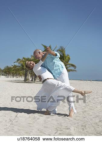 Stock Photo - Senior couple dancing on tropical beach. Fotosearch