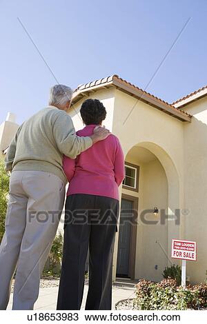 Senior couple examining exterior of house put on sale View Large Photo Image Stock Image - Senior couple examining exterior of house put on sale. Fotosearch
