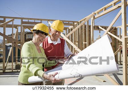 Senior man and woman examining blueprint in construction site View Large Photo Image Stock Photography - Senior man and woman examining blueprint in construction site. Fotosearch
