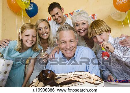 Stock Photograph - Senior man celebrating birthday with family. Fotosearch
