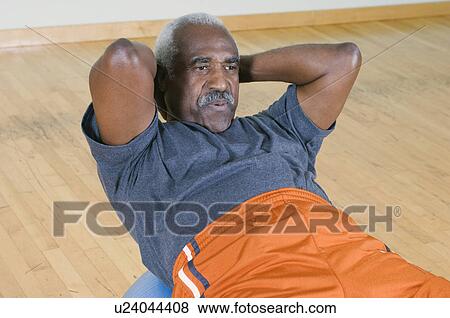 Stock Photo - Senior Man Doing Sit-Ups on Exercise Ball. Fotosearch