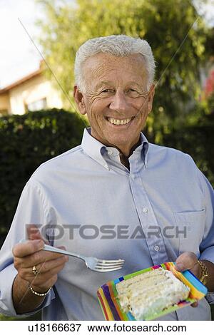 Senior man eating birthday cake View Large Photo Image Stock Photo - Senior man eating birthday cake. Fotosearch