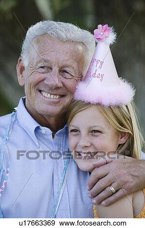 Stock Photo - Senior man embracing granddaughter. Fotosearch