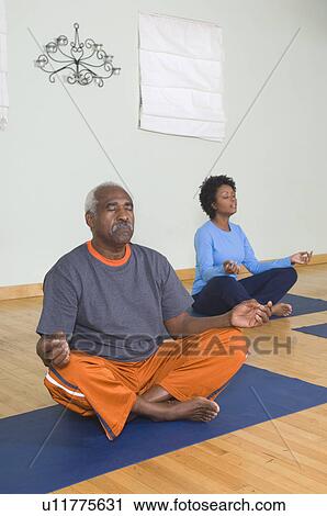 Stock Image - Senior Man Meditating in Yoga Class. Fotosearch