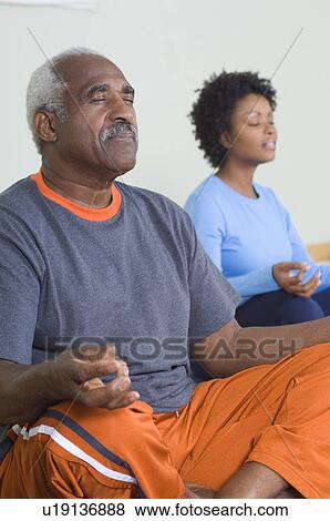 Stock Photo - Senior Man Meditating in Yoga Class. Fotosearch