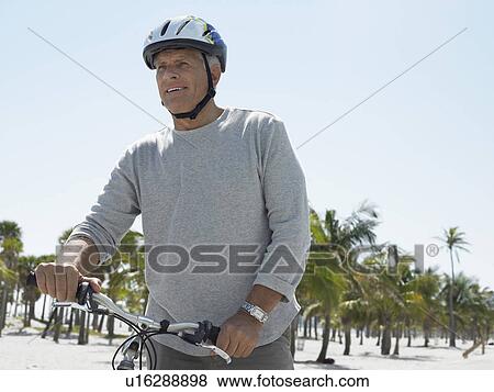 Senior man on bicycle on tropical beach View Large Photo Image Stock Photo - Senior man on bicycle on tropical beach. Fotosearch