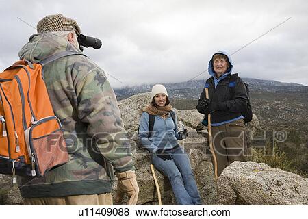 Stock Photo - Senior man using binoculars in mountains. Fotosearch