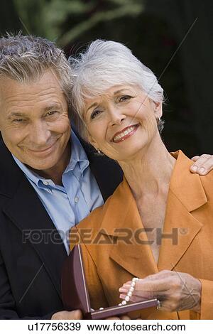 Senior man with senior woman holding pearl necklace View Large Photo Image Stock Photo - Senior man with senior woman holding pearl necklace. Fotosearch