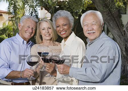 Stock Photo - Senior people raising toast in garden. Fotosearch