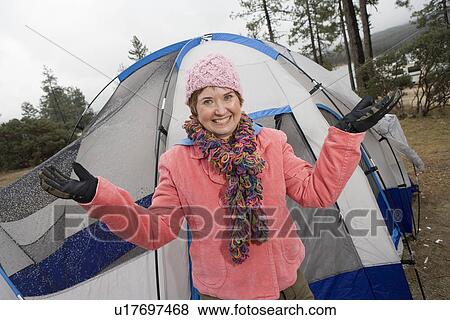 Stock Photo - Senior woman standing in front of tent, portrait. Fotosearch