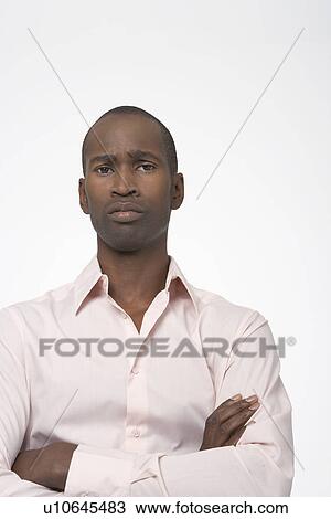 Stock Image - Serious Man standing with arms crossed. Fotosearch