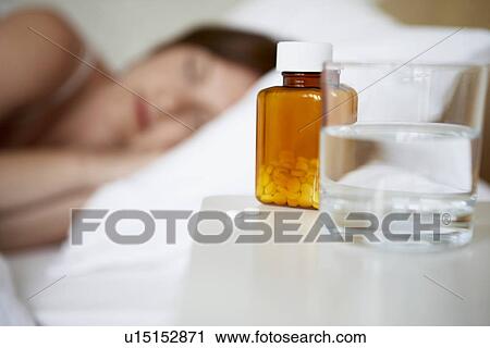 Sick woman in bed by pills on bedside table, focus on foreground View Large Photo Image Stock Image - Sick woman in bed by pills on bedside table, focus on foreground. Fotosearch