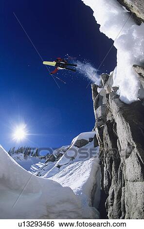 Skier jumping from cliff in mountains View Large Photo Image Stock Photograph - Skier jumping from cliff in mountains. Fotosearch