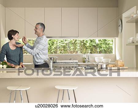 Smiling couple cooking together View Large Photo Image Stock Photograph - Smiling couple cooking together. Fotosearch