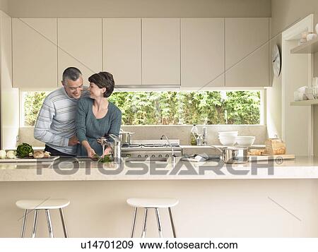 Stock Photo - Smiling couple in kitchen. Fotosearch