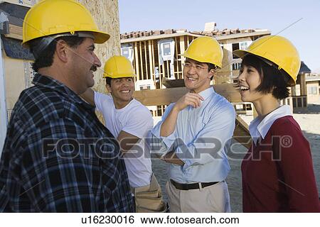 Smiling couple with construction workers View Large Photo Image Stock Photograph - Smiling couple with construction workers. Fotosearch