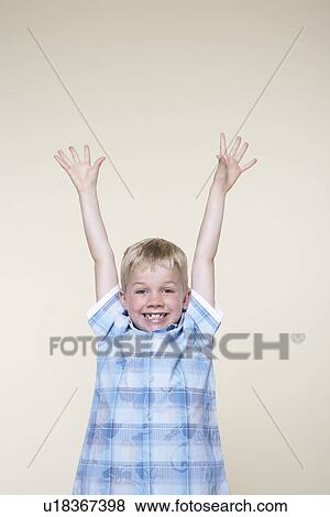 Smiling, excited boy standing with Arms Raised View Large Photo Image Stock Photo - Smiling, excited boy standing with Arms Raised. Fotosearch