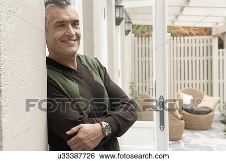 Smiling man standing at patio doors View Large Photo Image Stock Photograph - Smiling man standing at patio doors. Fotosearch