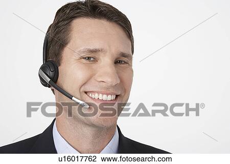 Stock Image - Smiling man talking on Telephone Headset. Fotosearch