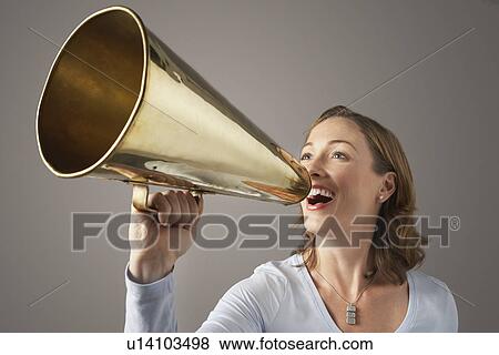 Smiling, Mid-adult woman shouting through megaphone View Large Photo Image Stock Photo - Smiling, Mid-adult woman shouting through megaphone. Fotosearch