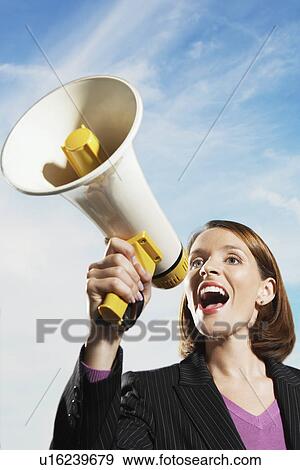 Smiling Mid-adult woman shouting through megaphone outside View Large Photo Image Stock Photo - Smiling Mid-adult woman shouting through megaphone outside. Fotosearch