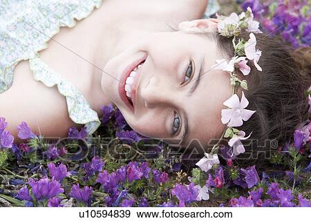 Smiling Pre-teen girl with flower headdress lying in field of flowers, close-up View Large Photo Image Stock Photo - Smiling Pre-teen girl with flower headdress lying in field of flowers, close-up. Fotosearch