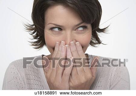 Smiling Woman, covering mouth with both hands, close-up View Large Photo Image Stock Image - Smiling Woman, covering mouth with both hands, close-up. Fotosearch