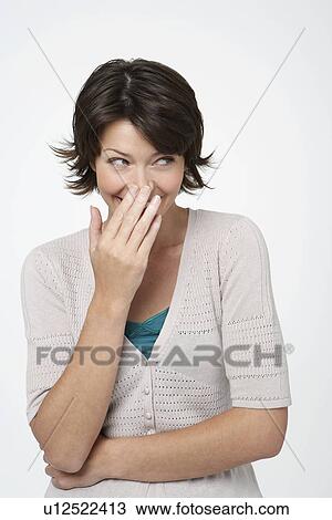 Smiling Woman standing, covering face with hand View Large Photo Image Stock Image - Smiling Woman standing, covering face with hand. Fotosearch