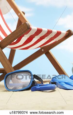 Picture - Snorkeling mask and flippers under deckchair on beach. Fotosearch