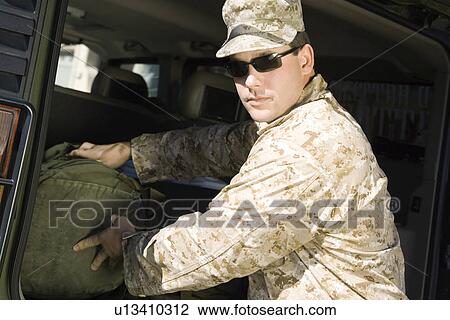 Soldier loading bag into vehicle, (portrait) View Large Photo Image Stock Image - Soldier loading bag into vehicle, (portrait). Fotosearch