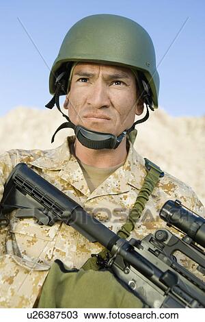 Stock Image - Soldier wearing helmet, outdoors, (close-up), (portrait). Fotosearch