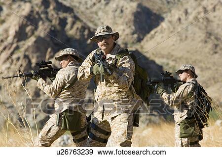Soldiers carrying rifles in the field View Large Photo Image Stock Photo - Soldiers carrying rifles in the field. Fotosearch